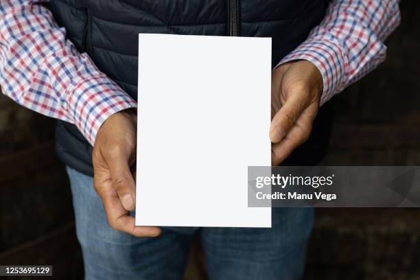 man hands show book, guy in plaid shirt, shows the white book, on camera - brochure stockfoto's en -beelden