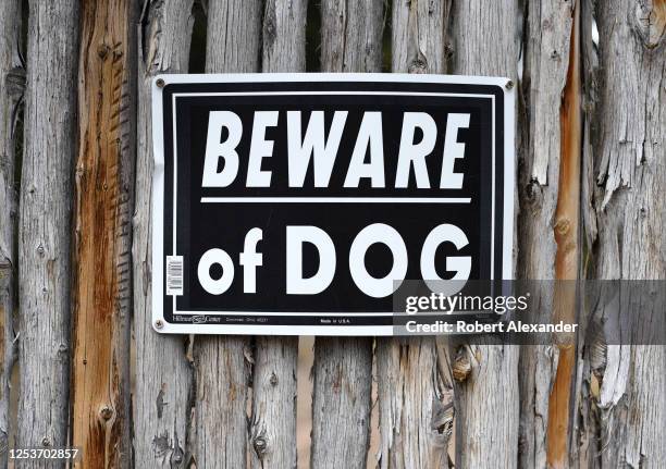 Beware of Dog' sign posted on a Southwestern 'coyote' fence in Santa Fe, New Mexico.