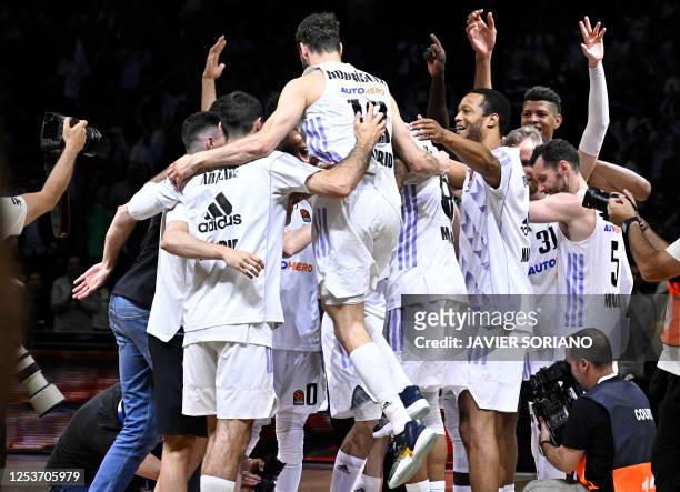 Real Madrid players celebrate their win at the end of the Euroleague quarter final basketball match between Real Madrid Baloncesto and Partizan...