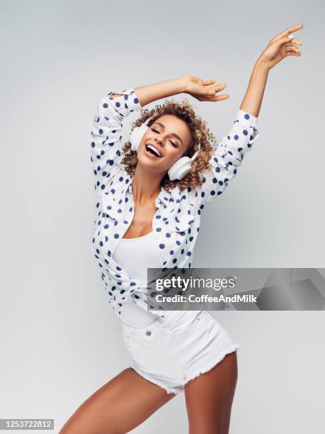 retrato de chica positiva alegre con auriculares en la cabeza escuchando música y bailando - women dancing on music cutout fotografías e imágenes de stock