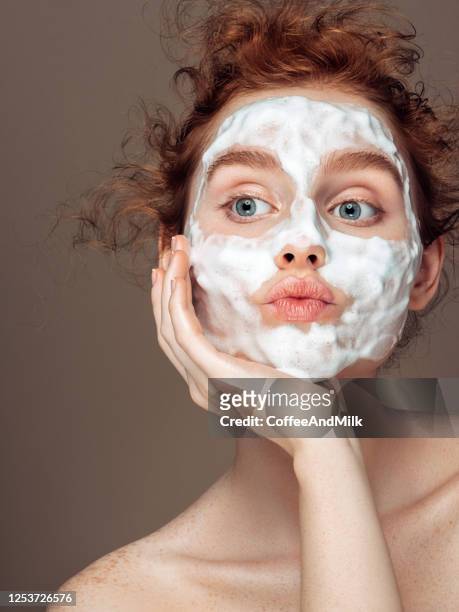 junge frau wendet schönheitsmaske - woman make up face wipes not men stock-fotos und bilder