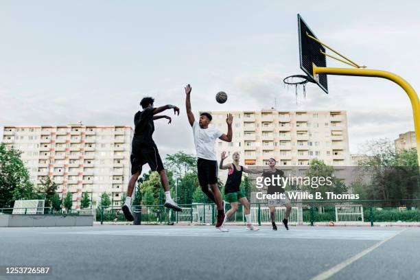friends playing basketball - leben in der stadt stock-fotos und bilder