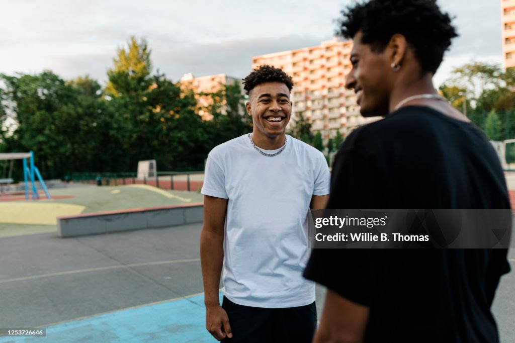 Two Black Friends Talking on Basketball Court