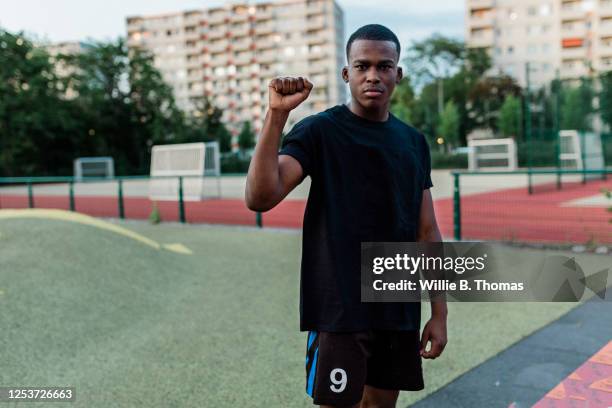 young black man with raised fist - fist raised stock pictures, royalty-free photos & images