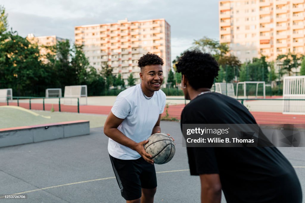Two friends playing one on one Basketball