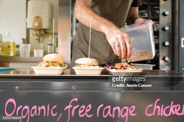 takeaway food being prepared on biodegradable plates in a food truck - foodtruck stockfoto's en -beelden