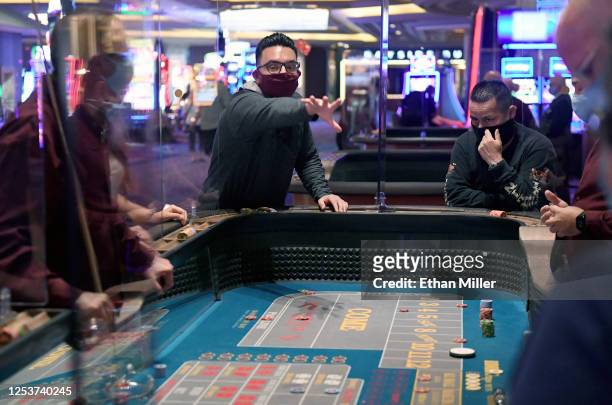 Daniel Hawkins of California rolls the dice at a craps table at Mandalay Bay Resort and Casino after the Las Vegas Strip property opened for the...