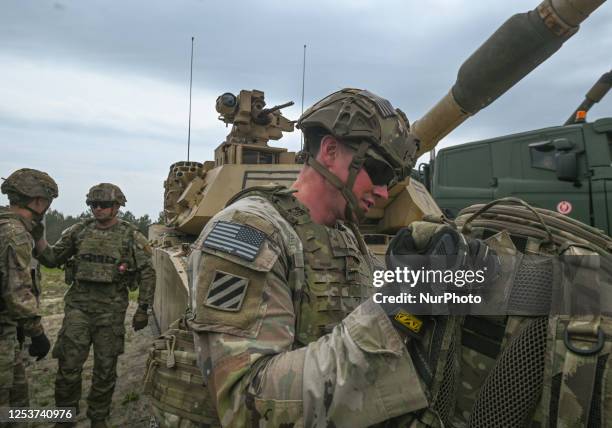 American soldiers are seen next to M1A2 Abrams tank during a high-intensity training session at the Nowa Deba training ground on May 06, 2023 in Nowa...