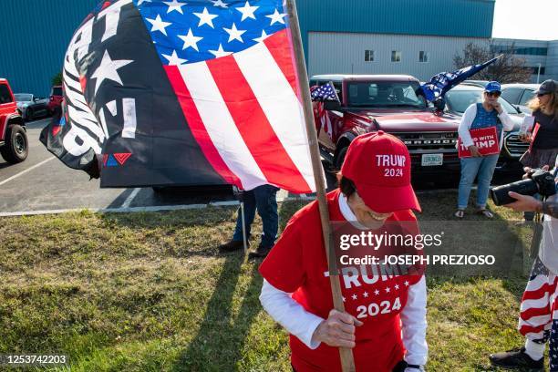 Supporters of former US President and 2024 Presidential hopeful Donald Trump rally to welcome him at Manchester airport in Manchester, New Hampshire,...