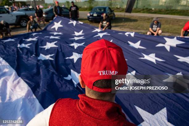 Supporters of former US President and 2024 Presidential hopeful Donald Trump rally to welcome him at Manchester airport in Manchester, New Hampshire,...