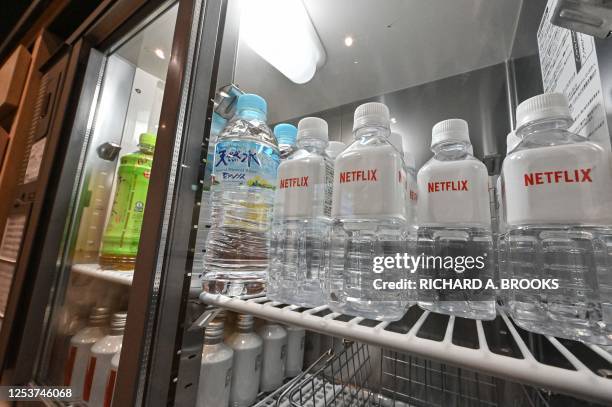 This photo taken on March 24, 2023 shows water bottles with the Netflix logo in a fridge during a media tour and press conference at the office of...