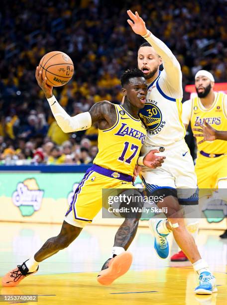 Los Angeles Lakers guard Dennis Schroder, left, drives to the basket while pressured by Golden State Warriors guard Stephen Curry during the first...