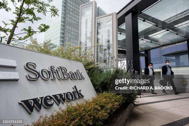 Pedestrians walk outside the headquarters for Japanese company SoftBank Group in Tokyo Portcity Takeshiba on May 11, 2023.