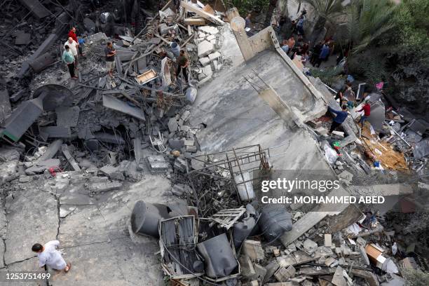 Palestinians inspect the rubble of a building, following an Israeli air strike, in Beit Lahia in the northern Gaza Strip on May 11, 2023. Israel's...