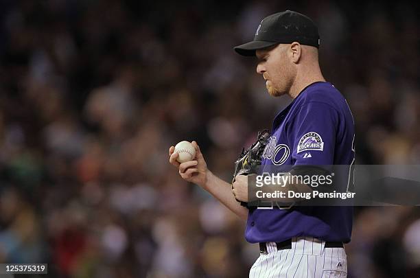 Aaron Cook of the Colorado Rockies pauses on the mound as he pitches in relief against the San Francisco Giants at Coors Field on September 16, 2011...