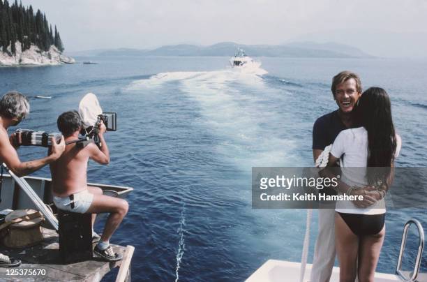 English actor Roger Moore as 007 with French actress Carole Bouquet as Melina Havelock on the set of the James Bond film 'For Your Eyes Only',...