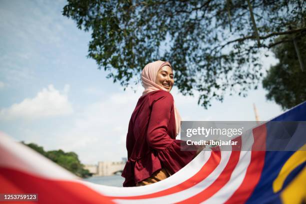 belle donne asiatiche che celebrano la giornata dell'indipendenza della malesia all'aperto - malaysia independence day foto e immagini stock