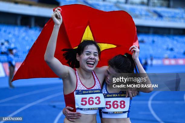 Vietnam's Thi Huyen Nguyen celebrates her victory with Vietnam's Thi Ngoc Nguyen after the women's 400m hurdles final during the 32nd Southeast Asian...