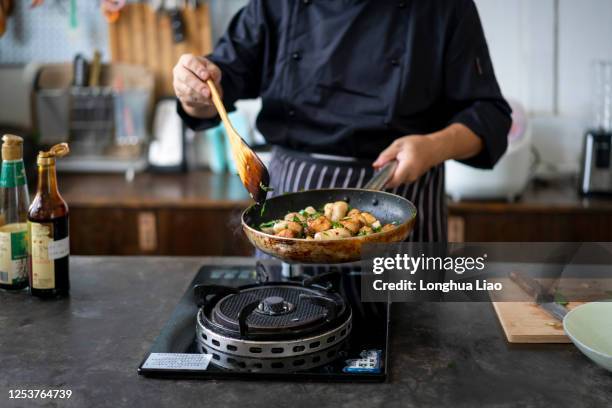 一個廚師在炒菜 - aliment frit photos et images de collection