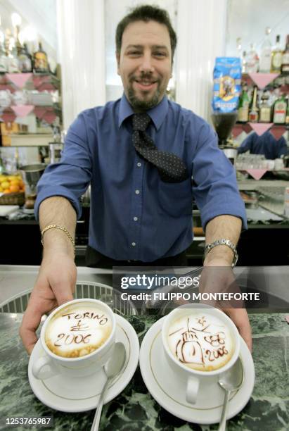 Alessandro Iacona, owner of a bar in central Turin, shows special cappuccinos he designed with 2006 Winter Olympic themes 10 November 2005 in Turin....