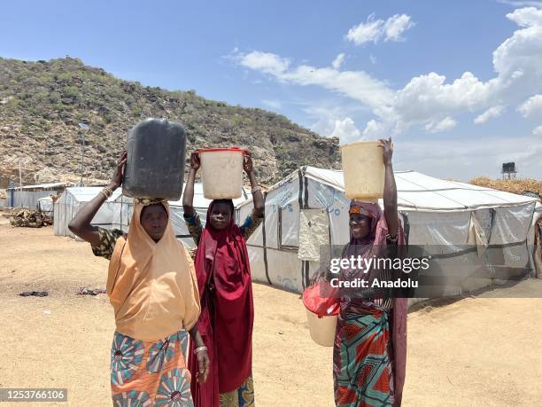 Women carry buckets of clean water on their head at the Gwoza IDP Camp in Borno State, Nigeria on May 03, 2023. While the number of people displaced...