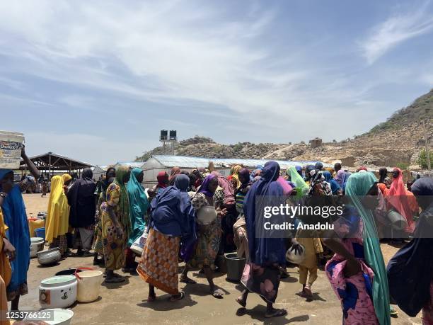 People wait to fill buckets with clean water from a water well at the Gwoza IDP Camp in Borno State, Nigeria on May 03, 2023. While the number of...