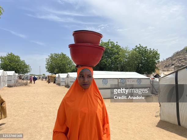 Nigerian woman carries a bucket of clean water on her head at the Gwoza IDP Camp in Borno State, Nigeria on May 03, 2023. While the number of people...