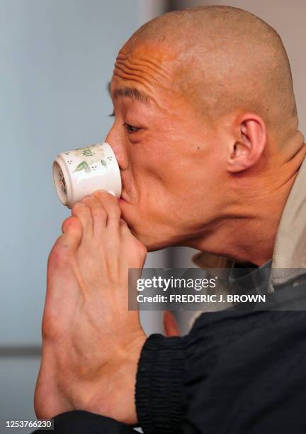 To go with "Lifestyle-China-art-disabled" by Frederic J. Brown Street artist Xi Fu , who's name means seeking happiness in English, sips tea from a...