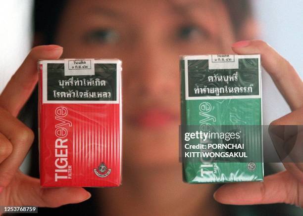 Model shows new cigaratte brand, Tigereye, launched by Thailand's Tobacco Monopoly 09 September 1999. The new brand is aimed at fighting against the...