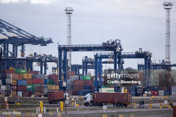 Trucks and shipping containers on the dockside at the Port of Felixstowe, owned by a unit of CK Hutchison Holdings Ltd., in Felixstowe, UK, on...
