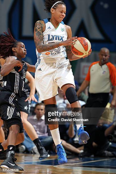Simone Augustus of the Minnesota Lynx secures the ball against Danielle Robinson of the San Antonio Silver Stars in Game One of the Western...