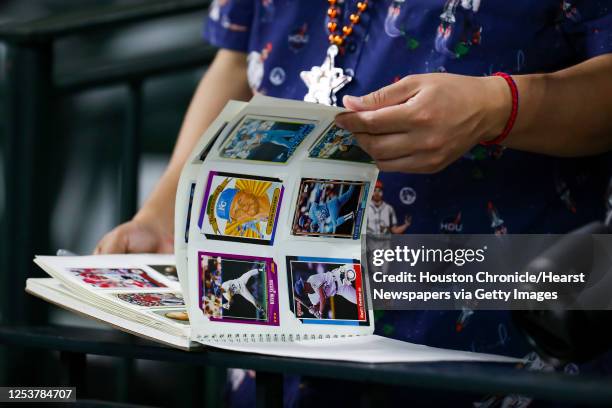 Fan flips through their baseball cards before Game 1 of the World Series on Tuesday, Oct. 26, 2021 at Minute Maid Park in Houston .