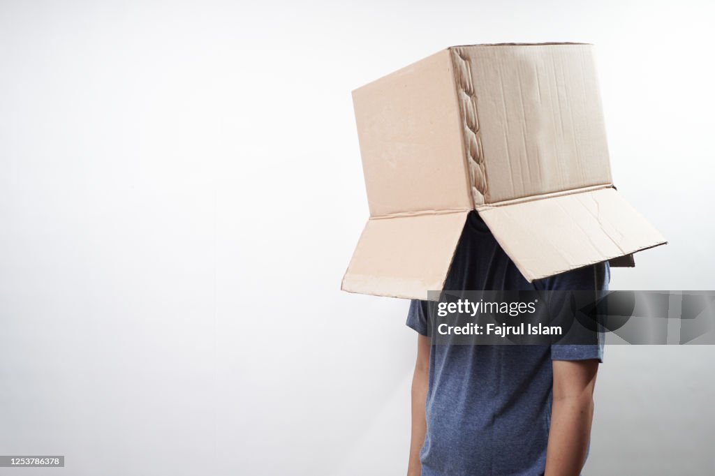 Cardboard boxes over faces of men