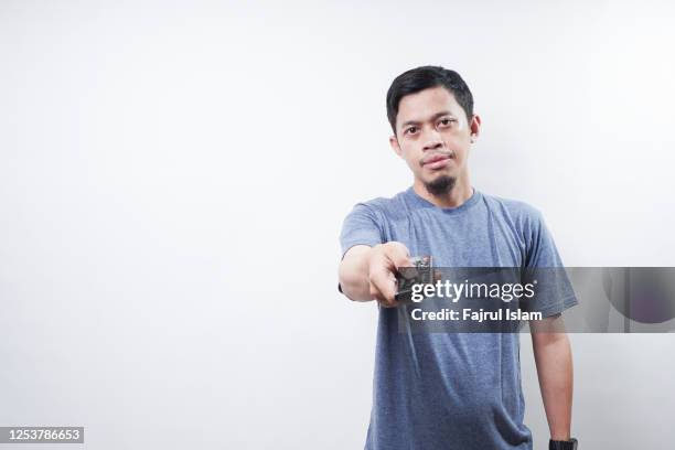 asian man holding remote tv - op afstand bediend stockfoto's en -beelden