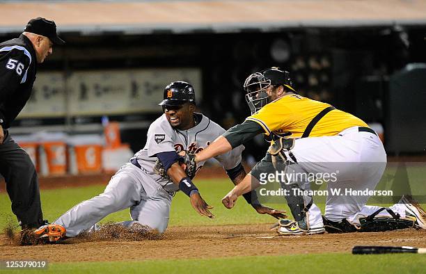 Wilson Betemit of the Detroit Tigers is tagged out at home plate by Landon Powell of the Oakland Athletics in the six inning during an MLB baseball...