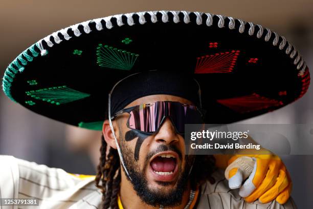 Fernando Tatis Jr. #23 of the San Diego Padres celebrates his home run while wearing a celebratory sombrero in the dugout in the first inning against...