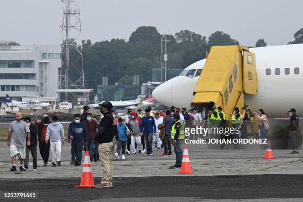 Guatemalan migrants deported from the United States walk on the airport runway upon their arrival at the Air Force Base in Guatemala City on May 11...