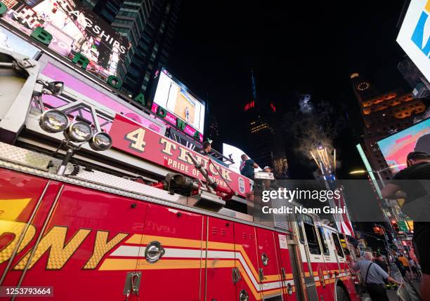 Firemen watch as fireworks burst at the One Times Square building in Times Square as part of the 44th annual Macy's 4th of July Fireworks Spectacular...