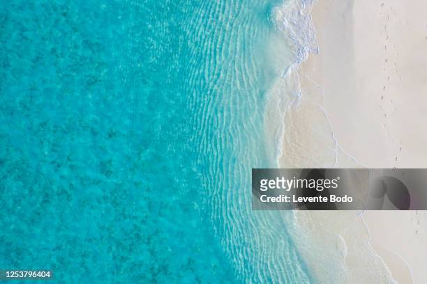 aerial view of sandy tropical beach in summer. aerial landscape of sandy beach and ocean with waves, view from drone or airplane. nature environment, peaceful bright zen, freedom scene - white bay stock pictures, royalty-free photos & images