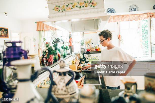 teenager boy making dinner at home - carol cook stock pictures, royalty-free photos & images