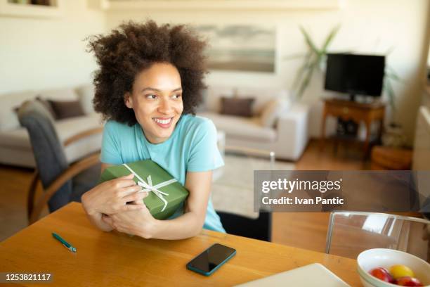 young african american woman holding a gift - freedom of expression is a right and not granted stock pictures, royalty-free photos & images