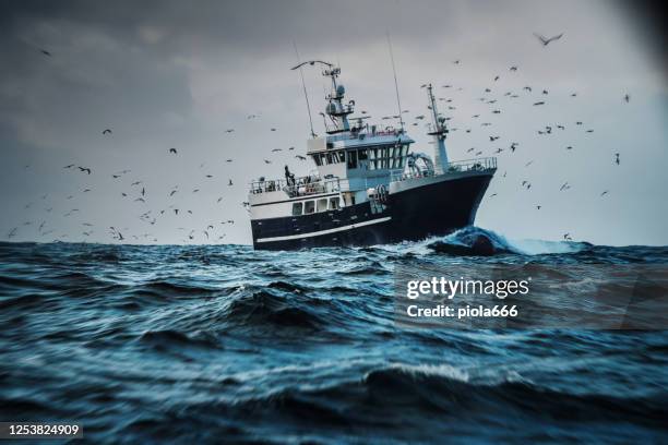 barco de barco de pescado que pesca en un mar agitado: arrastrero industrial - nautica fotografías e imágenes de stock