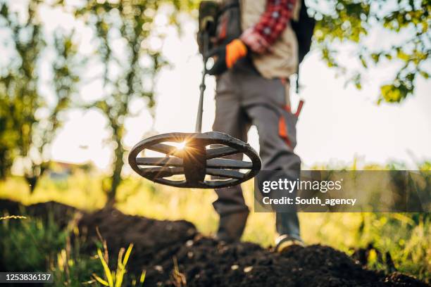 one senior man looking for treasure with a metal detector - vestido metalizado imagens e fotografias de stock