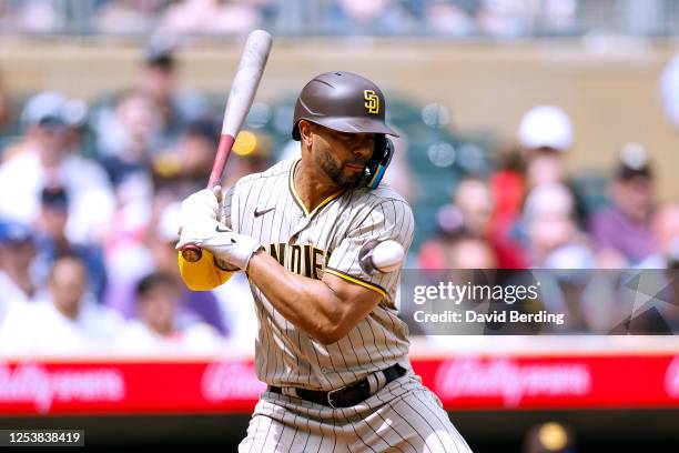 Xander Bogaerts of the San Diego Padres is hit by a pitch against the Minnesota Twins in the eighth inning at Target Field on May 11, 2023 in...