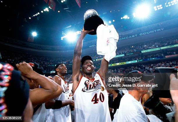 Tyrone Hill of the Philadelphia 76ers celebrates with the eastern conference trophy against the Milwaukee Bucks in Game seven of the 2001 Eastern...