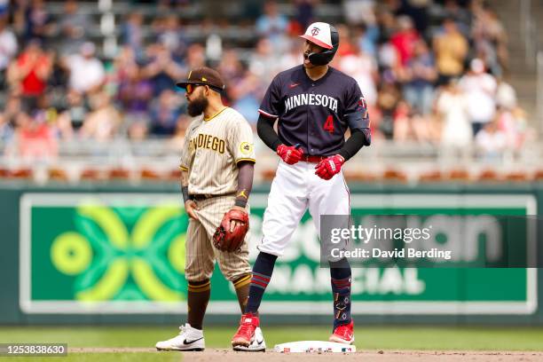 Carlos Correa of the Minnesota Twins celebrates his two RBI double while Rougned Odor of the San Diego Padres reacts in the seventh inning at Target...