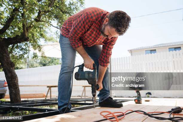 carpenter installing a wood floor outdoor terrace in new house construction site - flooring contractor stock pictures, royalty-free photos & images
