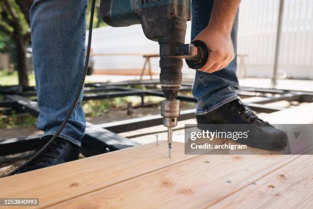 carpenter installing a wood floor outdoor terrace in new house construction site - flooring contractor stock pictures, royalty-free photos & images