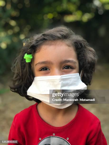 little girl is smiling behind the mask - iran coronavirus stock pictures, royalty-free photos & images