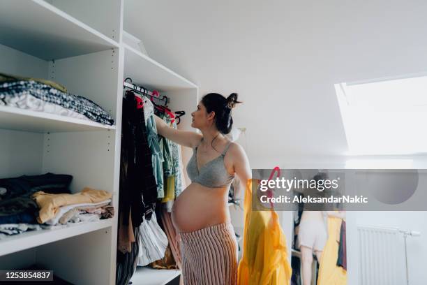 pregnant woman organizing her closet - cluttered closet stock pictures, royalty-free photos & images